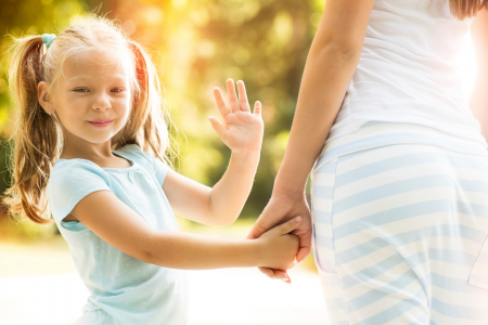 young girl smiling and waving