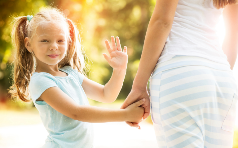 young girl smiling and waving